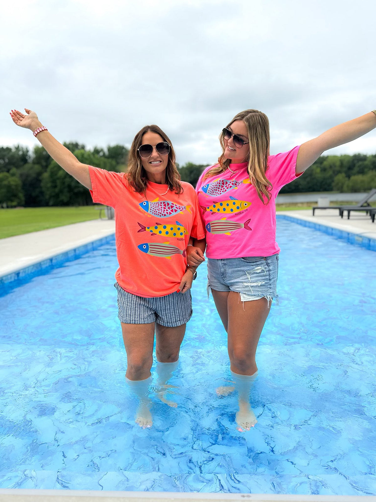 woman wearing a neon pink fisher of men christian comfort colors t-shirt by a swimming pool