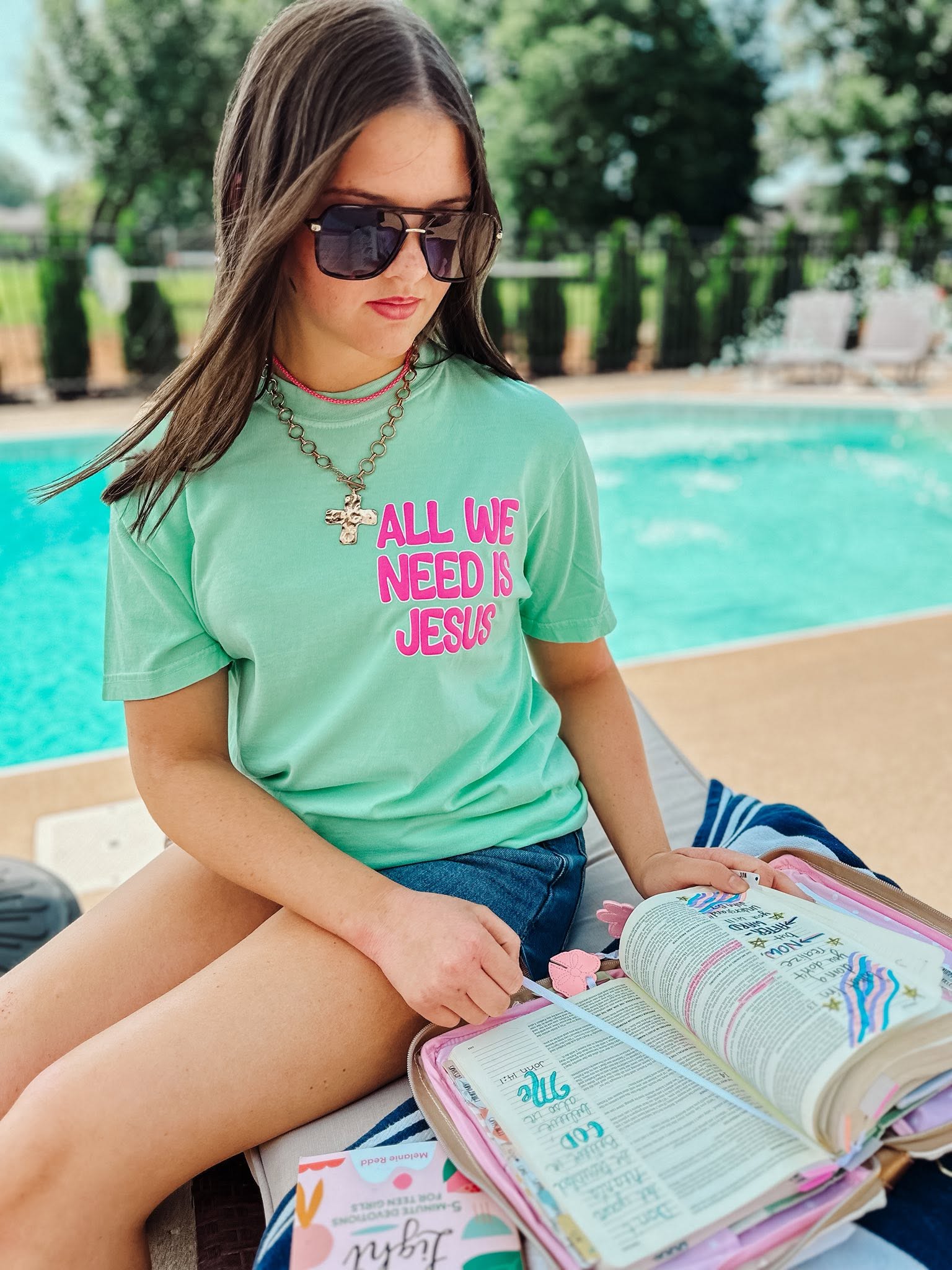woman wearing island reef christian t-shirt while reading her Bible outdoors